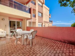 a patio with a table and chairs in front of a building at Studio vue mer avec Wi-Fi pour 4, Roquebrune-Cap-Martin - FR-1-827-92 in Roquebrune-Cap-Martin