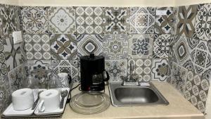 a kitchen counter with a sink and a coffee maker at Departamento Privado y Amplio en Zona Norte con Wifi cerca Centro in Mérida +64 photos