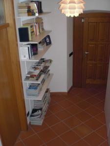 a book shelf filled with books next to a door at B&B Ai Castagni in Tenno +41 photos