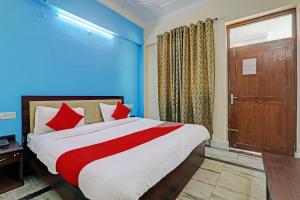 a bedroom with a bed with blue walls and a door at 81603 Hotel Shiva Grand in Chinhat