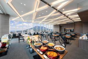 鹿児島市にあるホテルオリエンタルエクスプレス鹿児島天文館のダイニングルーム(テーブル、椅子、食べ物付)