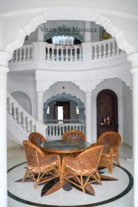 comedor con mesa y sillas de mimbre en Villa San Michele Home Stay, en Muttam