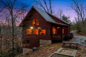 a log cabin in the woods at night at Tree Top Hideaway - Private with Games Firepit More in Blue Ridge