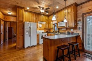 a kitchen with wooden cabinets and a white refrigerator at Tree Top Hideaway - Private with Games Firepit More in Blue Ridge