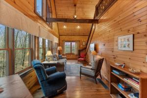 a living room in a cabin with wooden walls at Tree Top Hideaway - Private with Games Firepit More in Blue Ridge