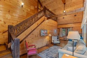 a living room with a staircase in a cabin at Tree Top Hideaway - Private with Games Firepit More in Blue Ridge