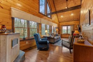 a living room with a fireplace in a log cabin at Tree Top Hideaway - Private with Games Firepit More in Blue Ridge