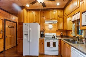 a kitchen with wooden cabinets and a white refrigerator at Tree Top Hideaway - Private with Games Firepit More in Blue Ridge