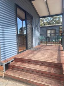 Robinvale Murray View Cabin的房屋内带桌椅的木制甲板