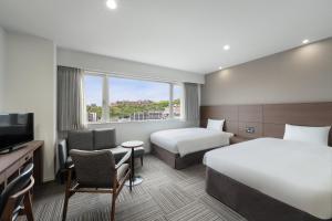 Postel nebo postele na pokoji v ubytování Hotel Oriental Express Kagoshima Tenmonkan