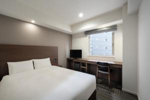 Postel nebo postele na pokoji v ubytování Hotel Oriental Express Kagoshima Tenmonkan