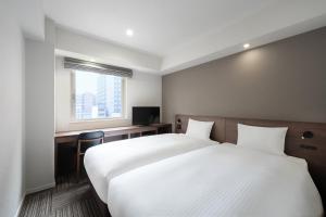 Postel nebo postele na pokoji v ubytování Hotel Oriental Express Kagoshima Tenmonkan