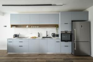 a kitchen with white cabinets and a refrigerator at Ramat Hasharon Chic Peaceful Stay by Sea N' Rent in Ramat Hash Sharon