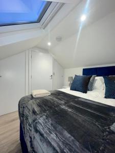 Un dormitorio con una cama grande y una claraboya. en Trinity Apartments - 2 Bed Apartment - sleeps 6 - Spacious - Modern - 30 Seconds from High Street, en Huntingdon