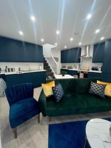 Una sala de estar con un sofá verde y una cocina. en Trinity Apartments - 2 Bed Apartment - sleeps 6 - Spacious - Modern - 30 Seconds from High Street, en Huntingdon 23 fotos más