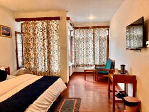 a bedroom with a bed and a desk and curtains at Tourist Hotel 10 minutes walking distance from the mall in Manāli