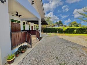 a house with a front porch with a fan at Tepak Nusuk Private Pool Homestay 5 Bedrooms 4 Bathrooms in Kota Bharu