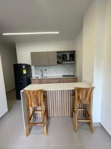 a kitchen with a table and two chairs and a counter at Cozy apartment in Apartadó in Apartadó