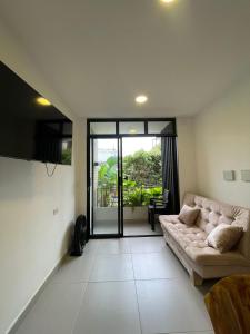 a living room with a couch and a large window at Cozy apartment in Apartadó in Apartadó
