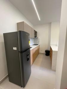 a kitchen with a black refrigerator in a room at Cozy apartment in Apartadó in Apartadó