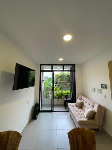 a living room with a couch and a flat screen tv at Cozy apartment in Apartadó in Apartadó +4 photos