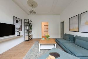 a living room with a blue couch and a table at Homey & Spacious 2BR Apt in the Heart of Tel-Aviv by Sea N' Rent in Tel Aviv