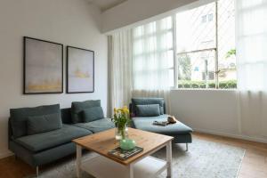a living room with a couch and a table at Homey & Spacious 2BR Apt in the Heart of Tel-Aviv by Sea N' Rent in Tel Aviv