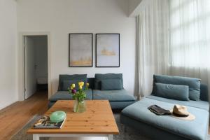 a living room with two blue couches and a table at Homey & Spacious 2BR Apt in the Heart of Tel-Aviv by Sea N' Rent in Tel Aviv
