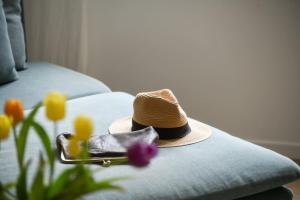 a hat sitting on top of a couch with flowers at Homey & Spacious 2BR Apt in the Heart of Tel-Aviv by Sea N' Rent in Tel Aviv +22 photos
