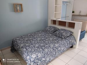 małą sypialnię z łóżkiem i półką w obiekcie Studio Gîtes des Colombières Piscine & Spa w mieście Saint-Maixent-sur-Vie