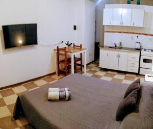 a bedroom with a large bed and a kitchen at MG Suites in Monte Grande