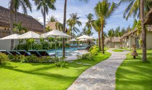 Coco Cottage Beachfront Resort في موي ني: ساحة منتجع فيها مسبح والنخيل +37 صورة