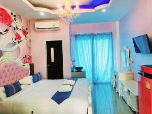 a bedroom with a large bed and a chandelier at The Linux Garden Hotel (City Amphur Muang Yala) in Yala