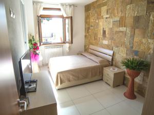 1 dormitorio con cama y pared de piedra en Affittacamere Casa Brajan, en Follonica