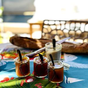 a table topped with four jars filled with food at La Cas'Aline in La Saline les Bains