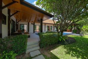 a house with a walkway leading into a yard at Villa Haeata | Gorgeous 3 bedroom villa in the secured residence in Nai Harn Beach