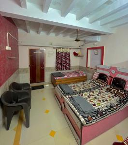 a room with two beds and a chair in it at Mahek Home Stay Dwarka in Dwarka