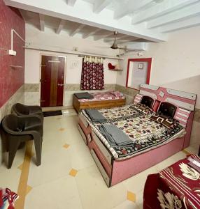 a room with two beds and a chair in it at Mahek Home Stay Dwarka in Dwarka