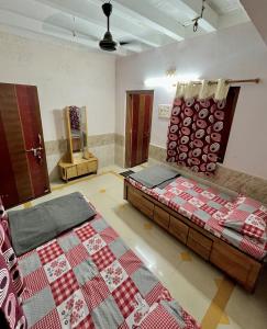 a room with a bed and a quilt on the wall at Mahek Home Stay Dwarka in Dwarka