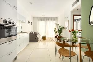 a kitchen and living room with a glass table at Eclectic Blue Apartment on Sheinkin by Sea N' Rent in Tel Aviv