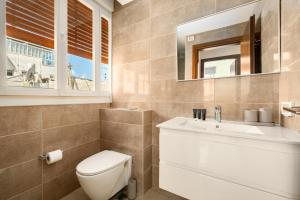 a bathroom with a toilet and a sink and a mirror at Eclectic Blue Apartment on Sheinkin by Sea N' Rent in Tel Aviv +34 photos