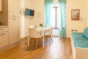 a dining room with a table and chairs and a bed at Carpione By Case al Lago in Desenzano del Garda