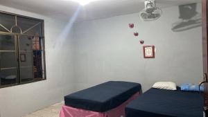 a room with two twin beds and a window at Lirio green hostal in Managua
