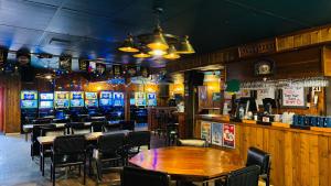 a bar with tables and chairs in a restaurant at Wakaw Inn in Wakaw