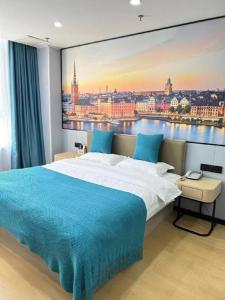 a bedroom with a large painting on the wall at Shell Hotel Taixing Huangqiao Town Dinghui Road in Hengxiang