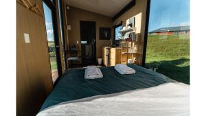 una camera da letto con un letto con due asciugamani sopra di Mighty Tiny House 2 by Tiny Away a Ruawaro