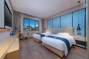 a hotel room with two beds and a large window at Echarm Hotel Nanchang Bayi Square Metro Station Wushang MALL in Nanchang +239 photos