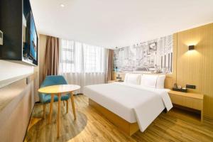 a hotel room with a large white bed and a table at City Comfort Inn Kunshan High-speed Railway Station Renmin Road in Suzhou +113 photos