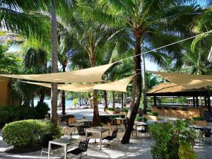 un patio con mesas y sillas con palmeras en Blue Chill private Pool Villa - Koh Chang, en Ko Chang