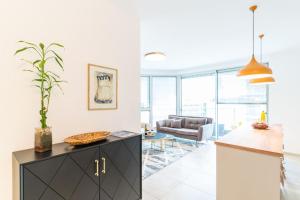 a kitchen and living room with a couch and a table at Sunlit Urban Escape with Balcony with Mamad by Sea N' Rent in Tel Aviv +34 photos